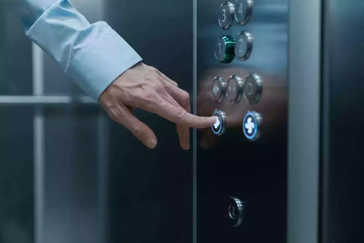 Un hombre aprieta el botón de un ascensor