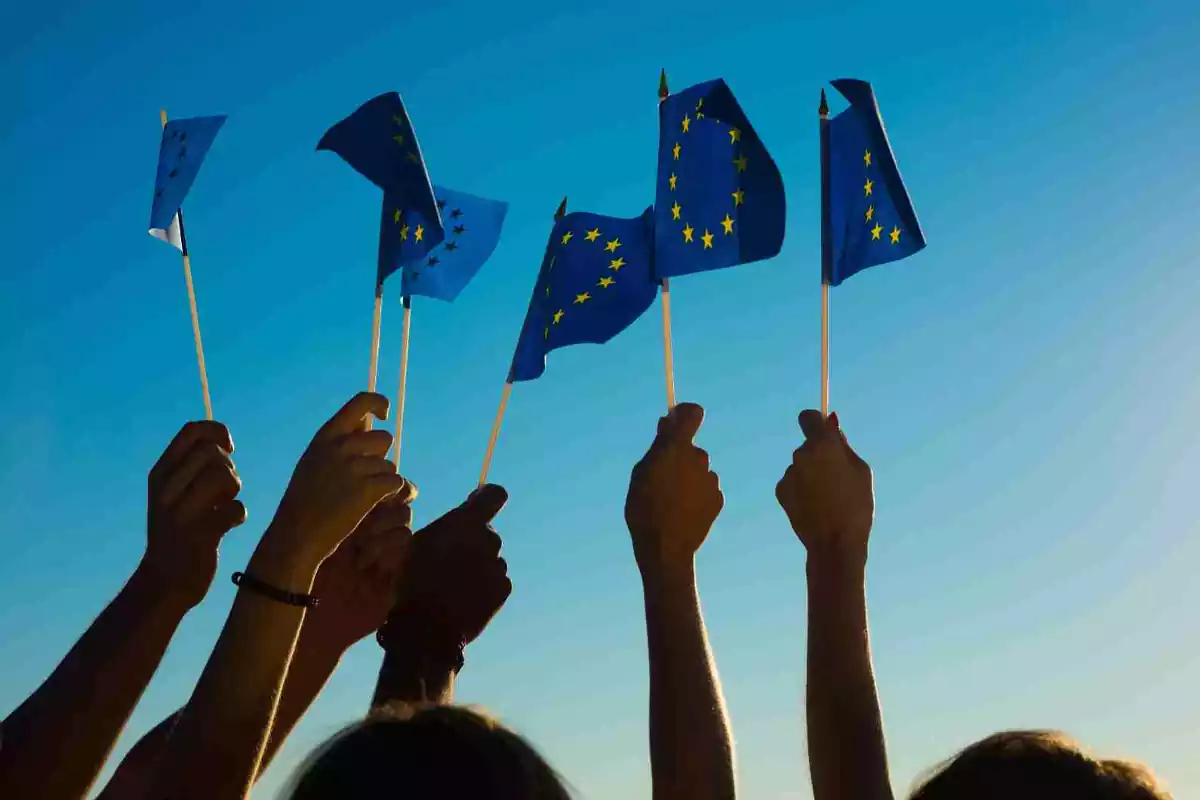 Personas levantan banderas de la UE