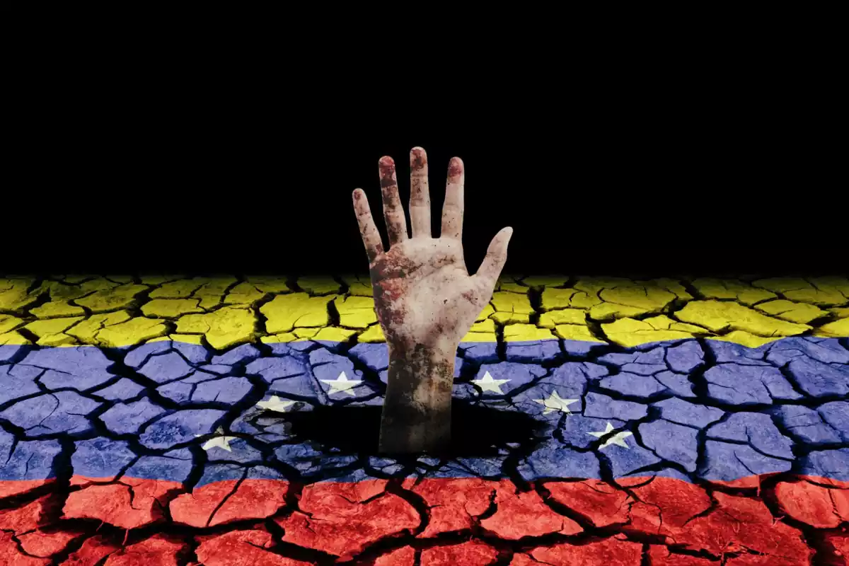 Una mano sale del interior de una bandera de Venezuela
