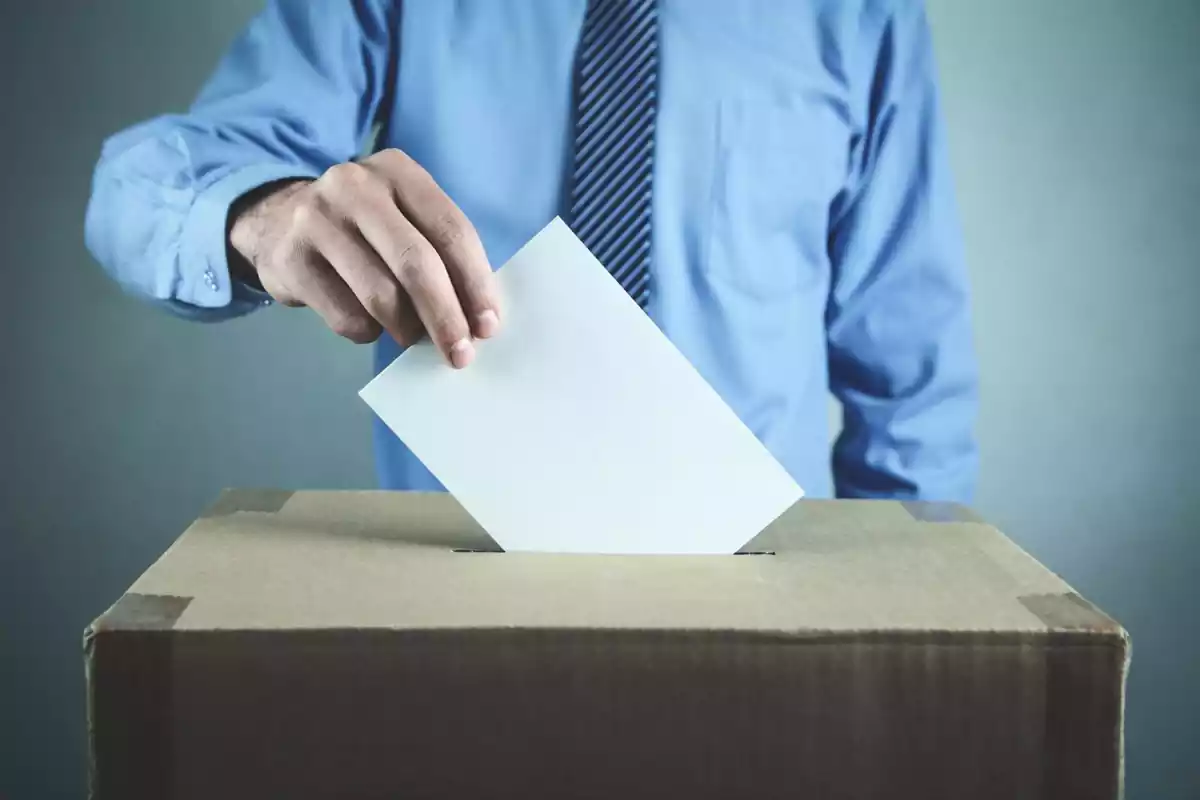 Un hombre pone su voto en una urna