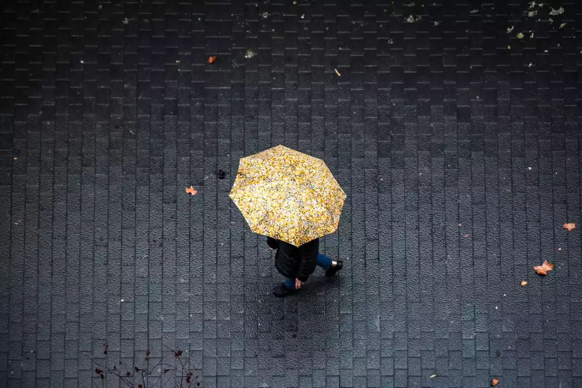 Una persona camina con un paraguas en Cataluña