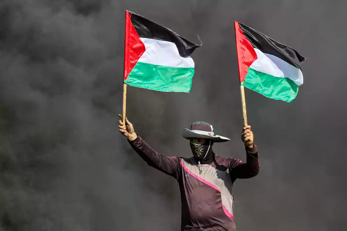 Imagen de archivo de palestinos ondeando la bandera de Palestina durante una protesta