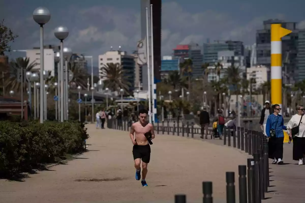 Un hombre corre por Barcelona con las temperaturas altas de este abril, propias de junio