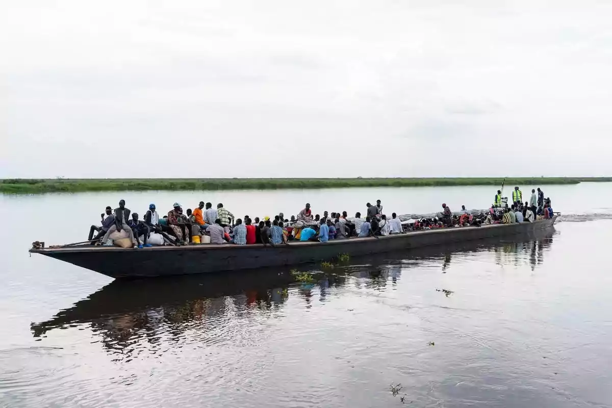 Refugiados sudaneses y retornados de Sudán del Sur toman una barcaza en el puerto de Renk, Sudán del Sur.