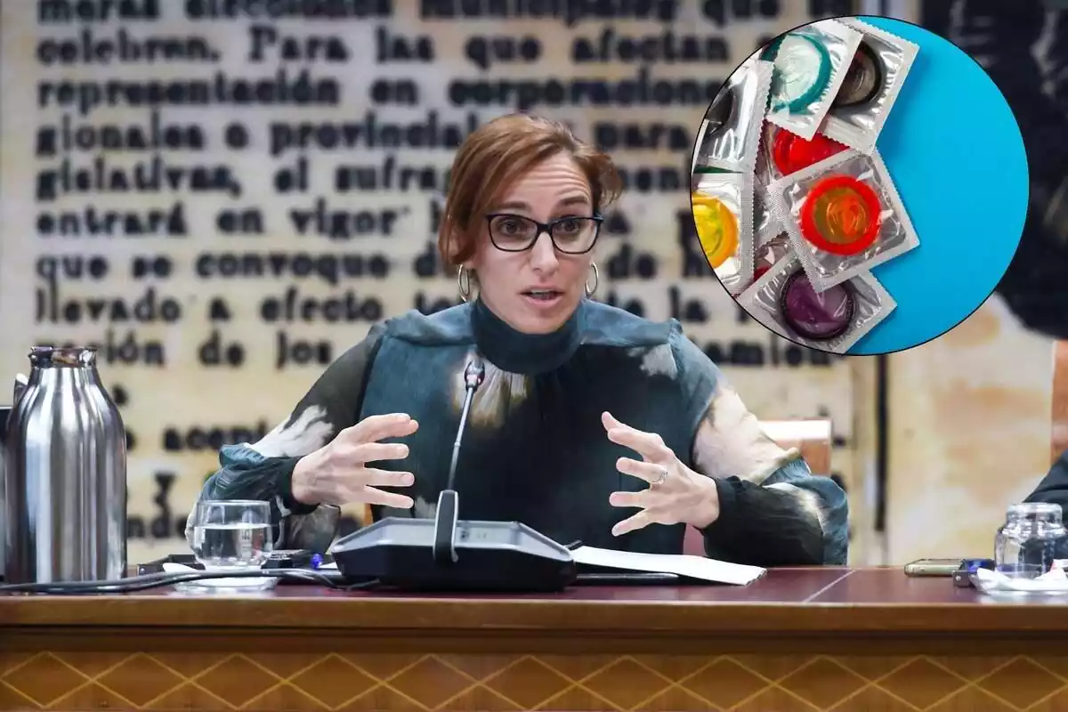 La ministra de Sanidad Mónica García junto con una imagen de preservativos
