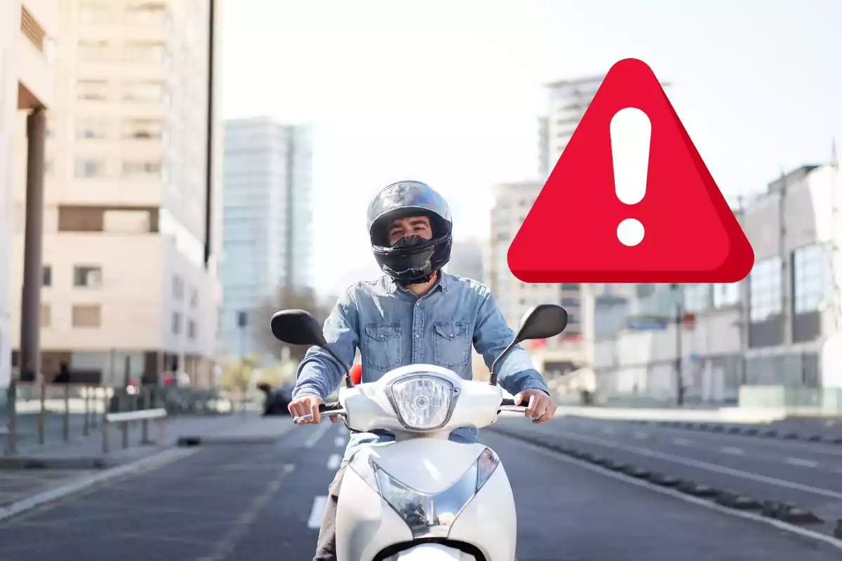 Un hombre monta sobre una moto en una ciudad en un fotomontaje con una señal de alerta