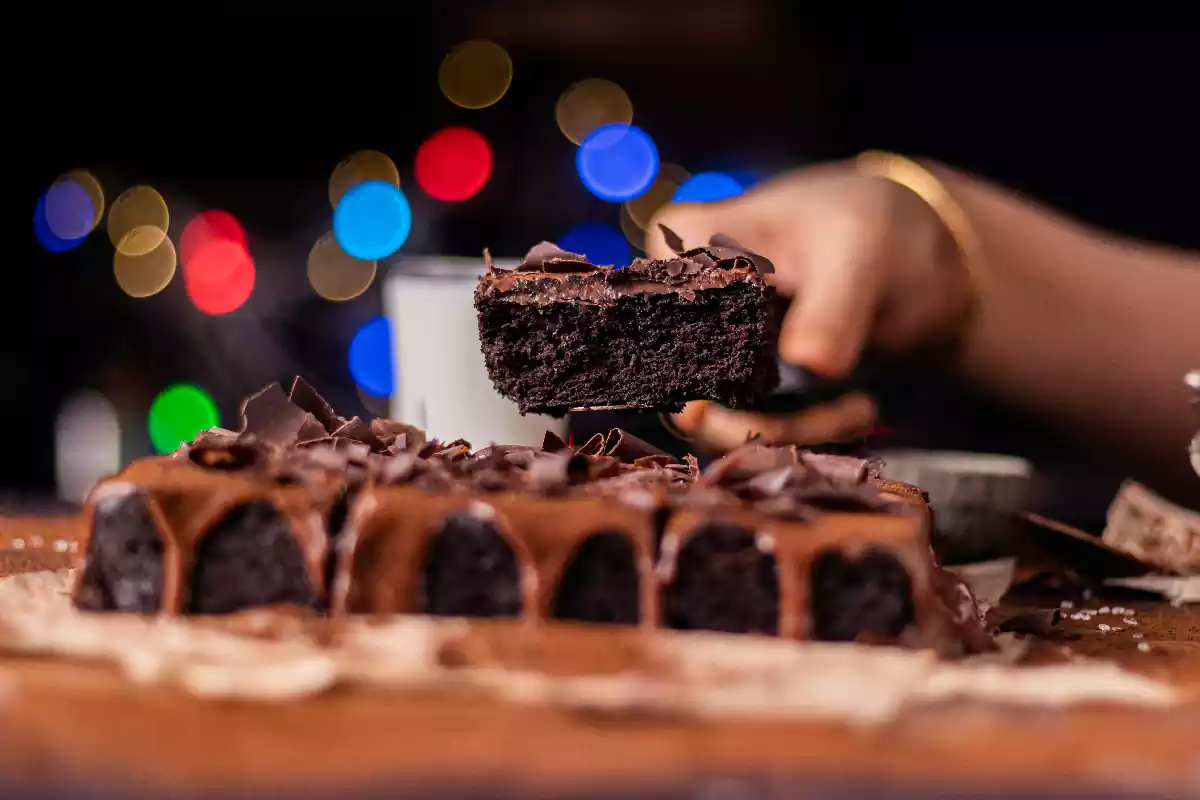 Una persona sirve un pastel de chocolate